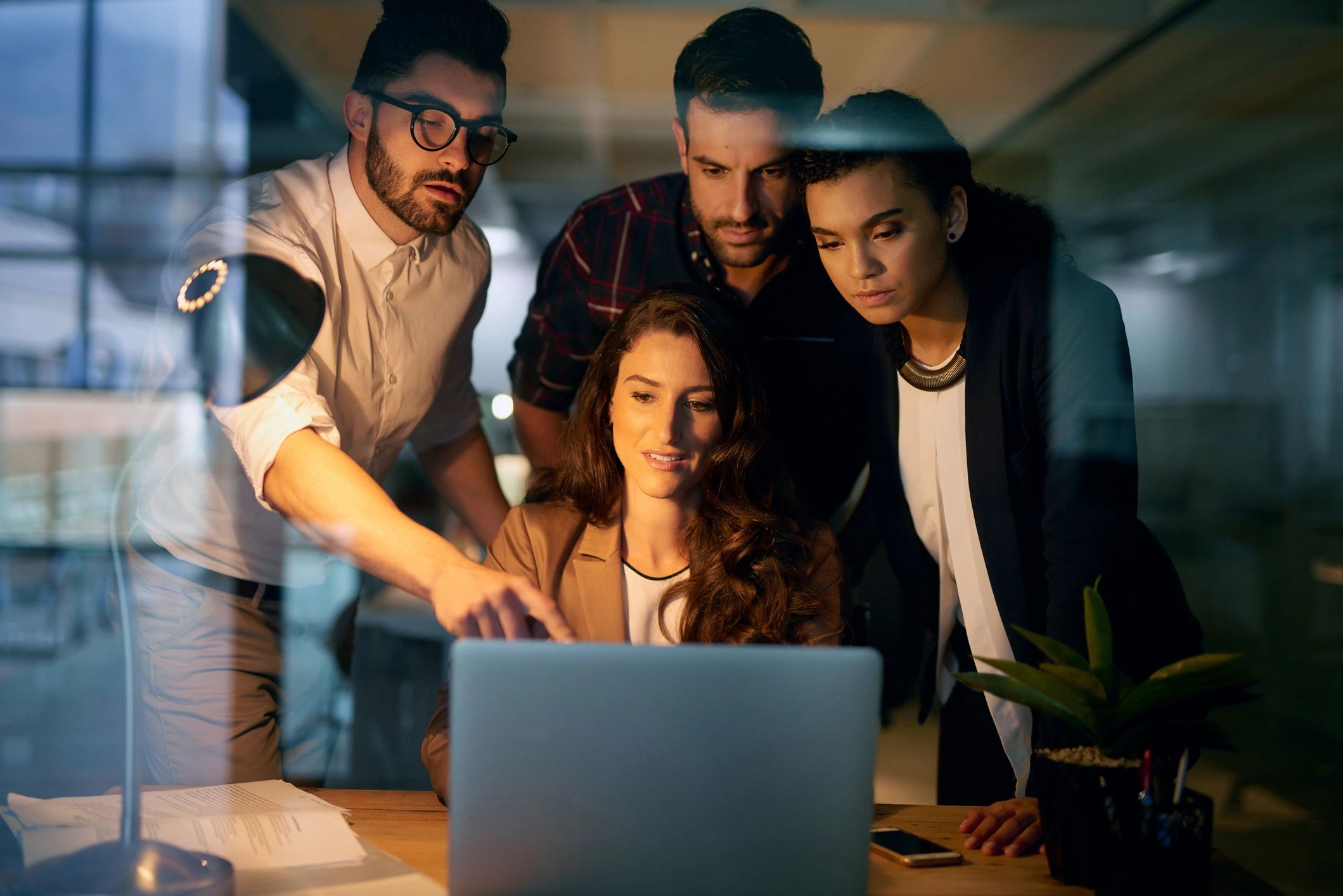 Software developers collaborating around a laptop